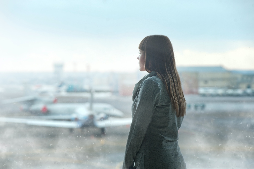 woman looking at an airplane from the airport