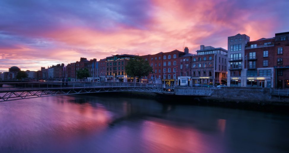 Apartments along the River Laffey in Dublin, Ireland during a pink sunset.