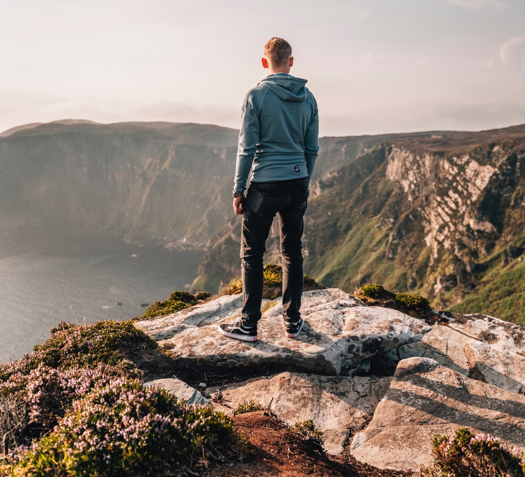 man looking over Irish cliffs