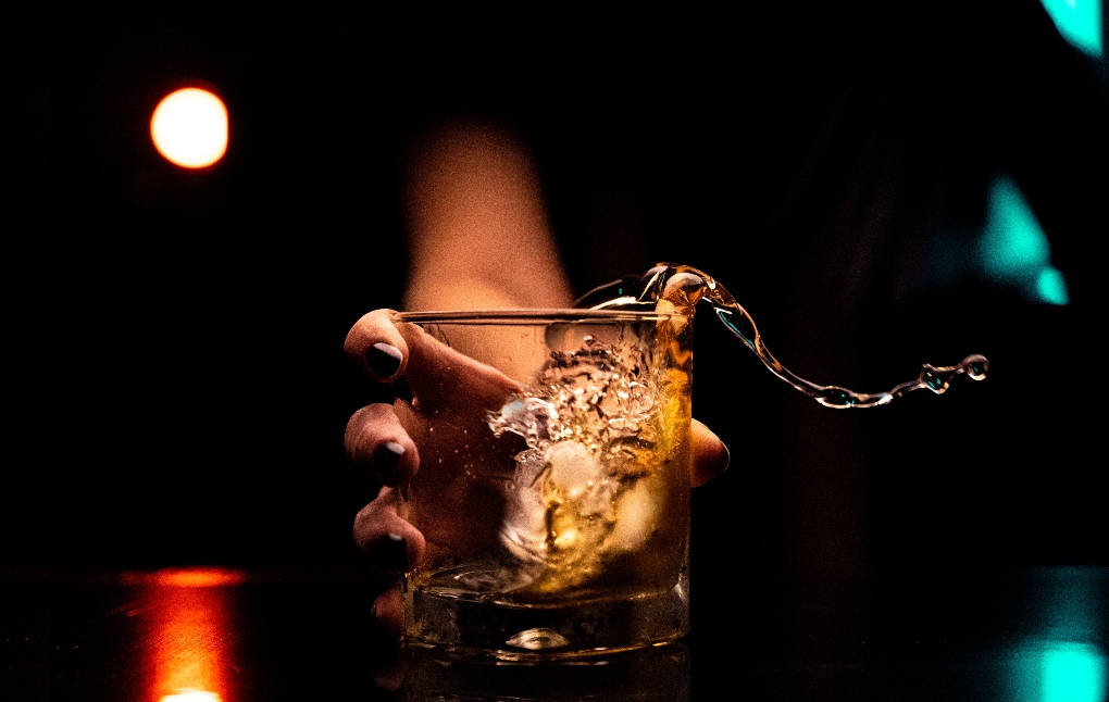 woman handing whiskey
