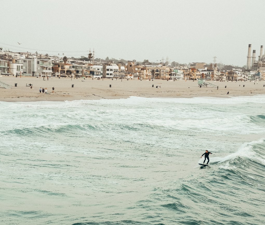 View of Hermosa Beach with the town and a surfer
