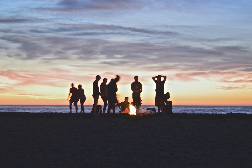 group of people having a beach bonfire