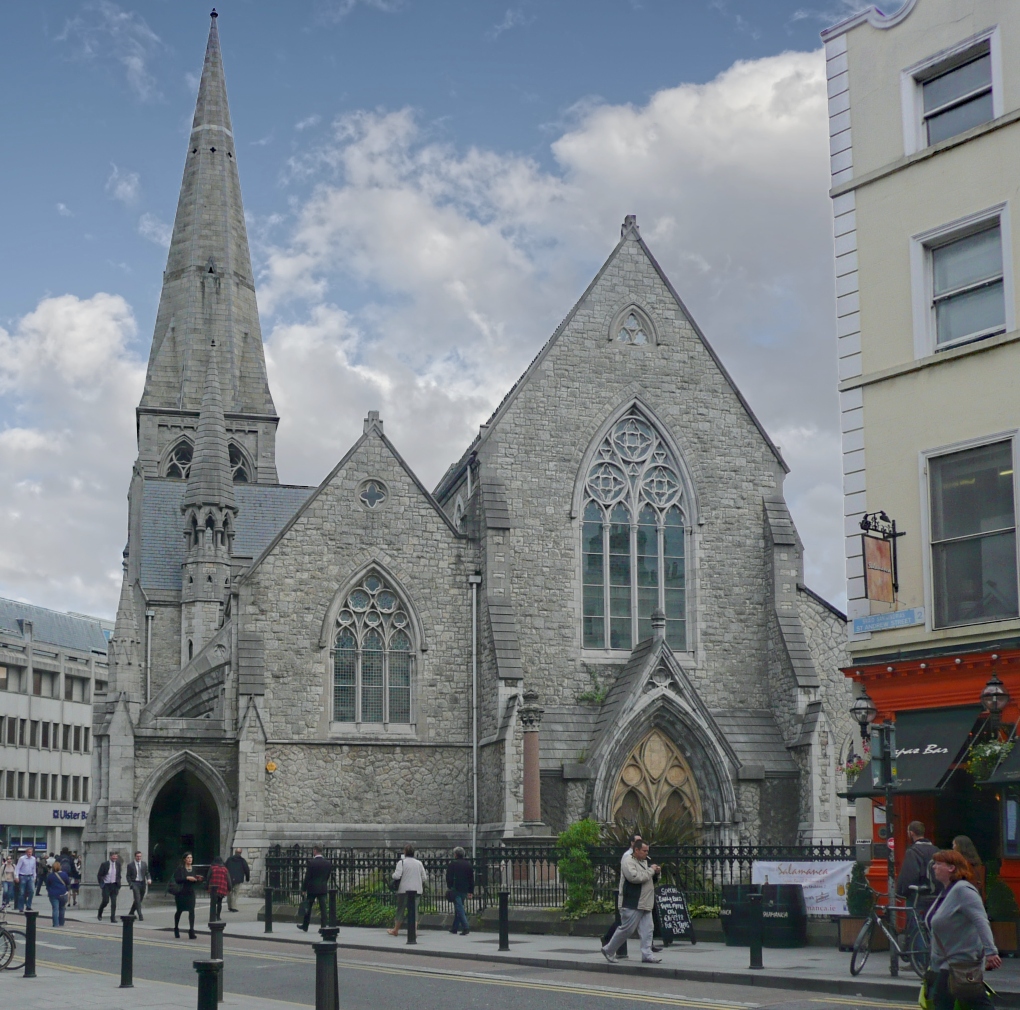 people walking past a church in Dublin