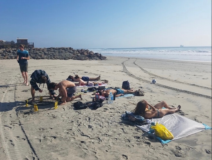 group of friends laying on the beach in Rosarito